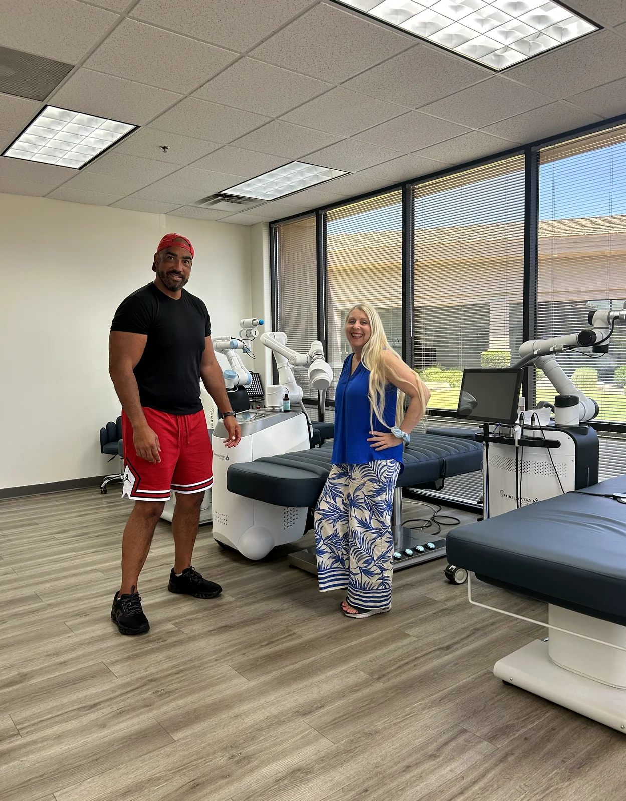 Devin Clark with Tina of V.Juv in the treatment room, alongside both PainRecovery machines